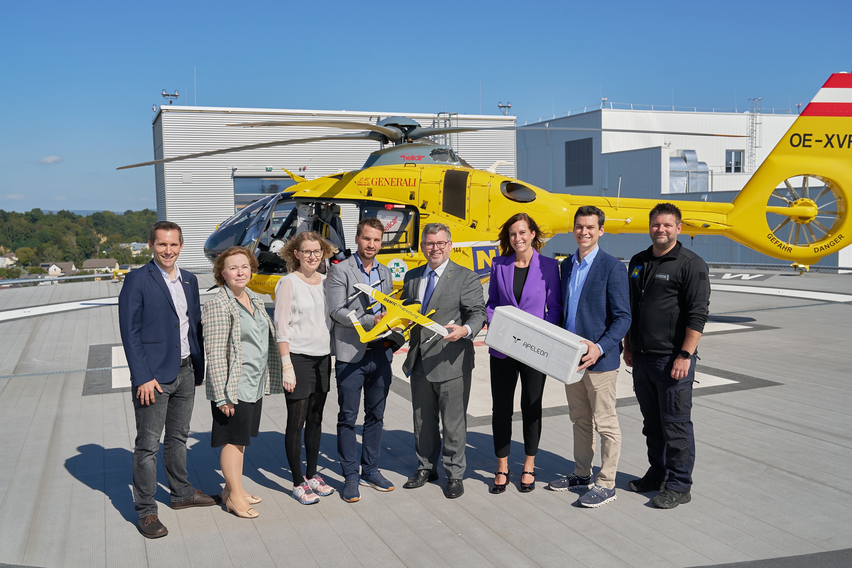 Partnerunternehmen mit LR Schleritzko auf dem Hubschrauberlandeplatz mit einer Transportdrohne in der Hand